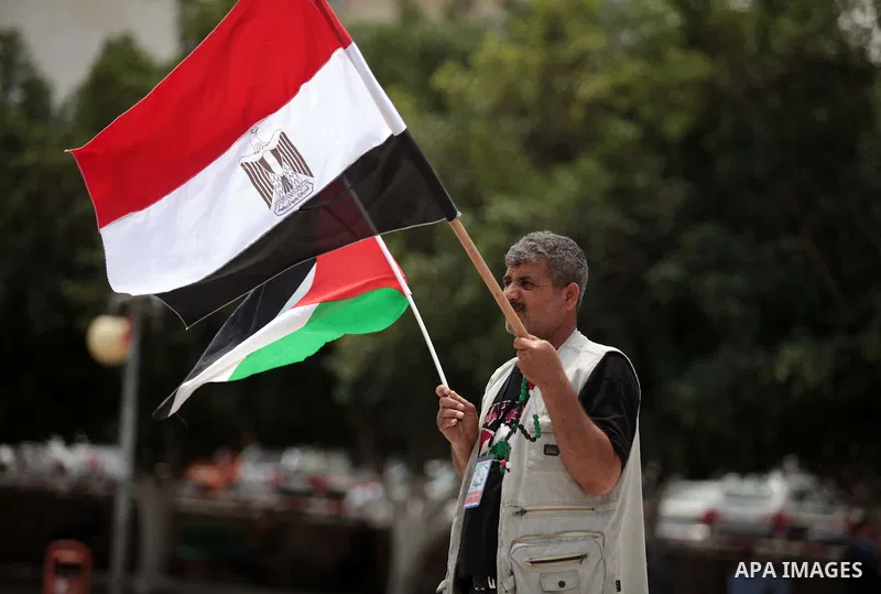 A Palestinian man holds a Palestinian and an Egyptian flag during a celebrate the announcement of the unity government and former Army chief Abdel Fattah al-Sisi winning the presidential election, in Gaza city on June 03...