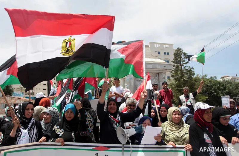 Palestinians hold Palestinian and Egyptian flags during a celebrate the announcement of the unity government and former Army chief Abdel Fattah al-Sisi winning the presidential election, in Gaza city on June 03, 2014. Pr...