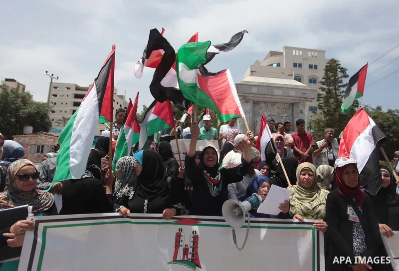 Palestinians hold Palestinian and Egyptian flags during a celebrate the announcement of the unity government and former Army chief Abdel Fattah al-Sisi winning the presidential election, in Gaza city on June 03, 2014. Pr...