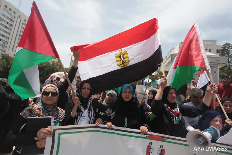 Palestinians hold Palestinian and Egyptian flags during a celebrate the announcement of the unity government and former Army chief Abdel Fattah al-Sisi winning the presidential election, in Gaza city on June 03, 2014. Pr...