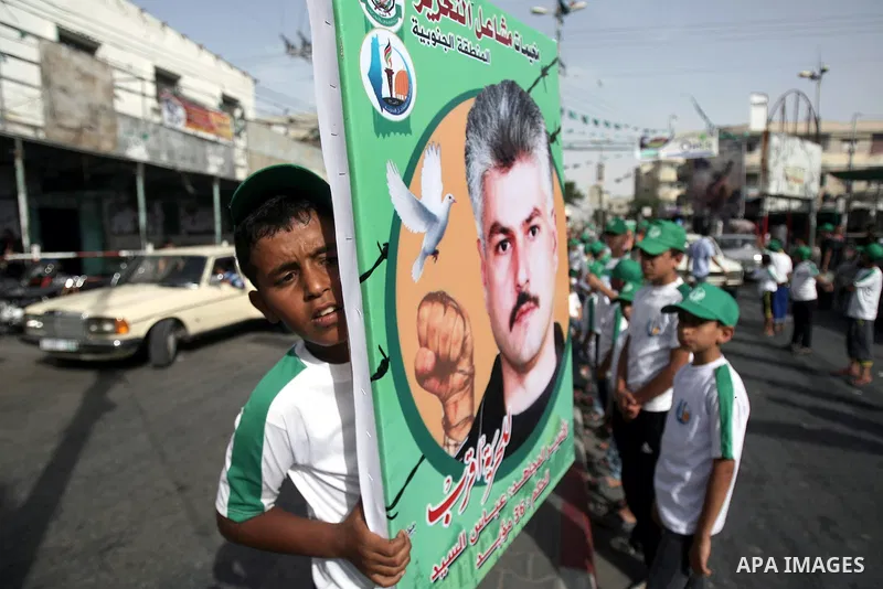 Palestinian children who participate in a summer camp organized by Hamas, hold placards as they parade the streets during a rally to show solidarity with Palestinian prisoners held in Israeli jails, in Rafah in the south...