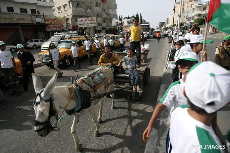 Palestinian children who participate in a summer camp organized by Hamas, hold placards as they parade the streets during a rally to show solidarity with Palestinian prisoners held in Israeli jails, in Rafah in the south...