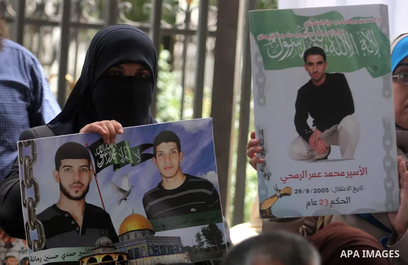 Palestinians hold prisoners pictures who held in Israeli jails during a protest to show solidarity with prisoners on hunger strike, outside the Red Cross headquarter in the West Bank City of Ramallah, June 03, 2014. Abou...