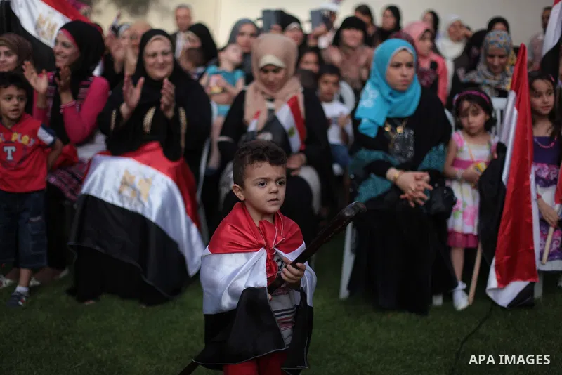 Members of Egyptian community in the Gaza Strip hold Egyptian flags and pictures of ex-army chief Abdel Fattah al-Sisi as they celebrate after Sisi scored a crushing presidential election triumph, in Gaza City on June 03...