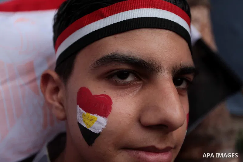 Members of Egyptian community in the Gaza Strip hold Egyptian flags and pictures of ex-army chief Abdel Fattah al-Sisi as they celebrate after Sisi scored a crushing presidential election triumph, in Gaza City on June 03...