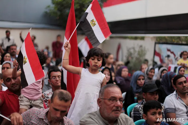 Members of Egyptian community in the Gaza Strip hold Egyptian flags and pictures of ex-army chief Abdel Fattah al-Sisi as they celebrate after Sisi scored a crushing presidential election triumph, in Gaza City on June 03...