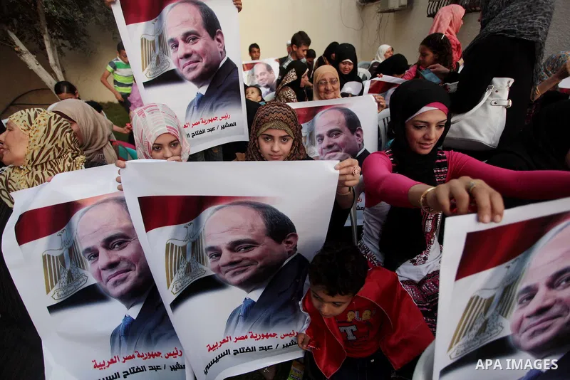 Members of Egyptian community in the Gaza Strip hold Egyptian flags and pictures of ex-army chief Abdel Fattah al-Sisi as they celebrate after Sisi scored a crushing presidential election triumph, in Gaza City on June 03...