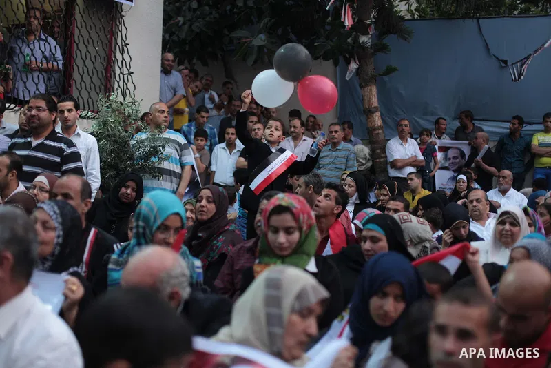 Members of Egyptian community in the Gaza Strip hold Egyptian flags and pictures of ex-army chief Abdel Fattah al-Sisi as they celebrate after Sisi scored a crushing presidential election triumph, in Gaza City on June 03...