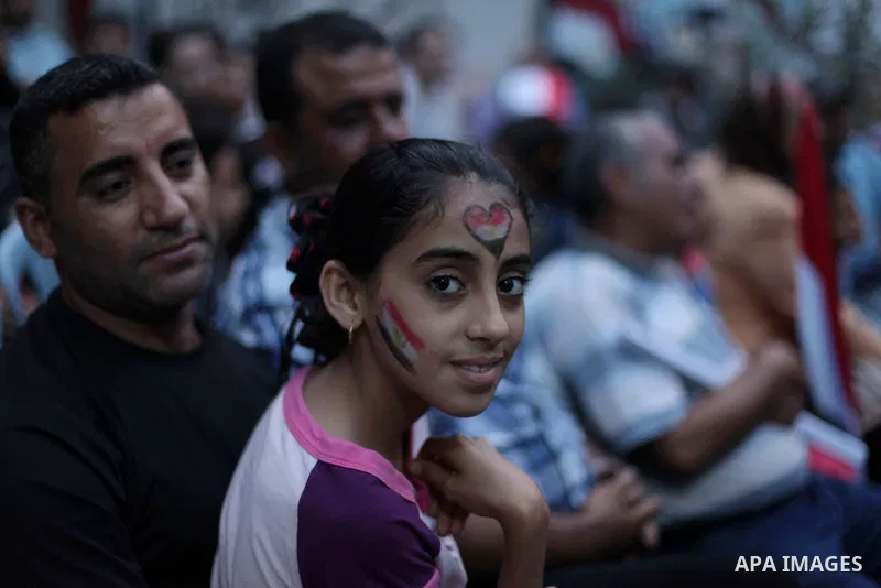 Members of Egyptian community in the Gaza Strip hold Egyptian flags and pictures of ex-army chief Abdel Fattah al-Sisi as they celebrate after Sisi scored a crushing presidential election triumph, in Gaza City on June 03...