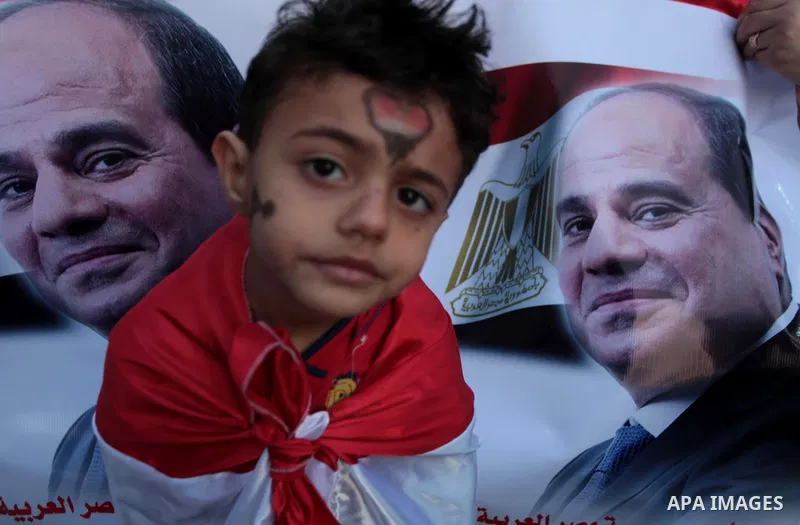 Members of Egyptian community in the Gaza Strip hold Egyptian flags and pictures of ex-army chief Abdel Fattah al-Sisi as they celebrate after Sisi scored a crushing presidential election triumph, in Gaza City on June 03...