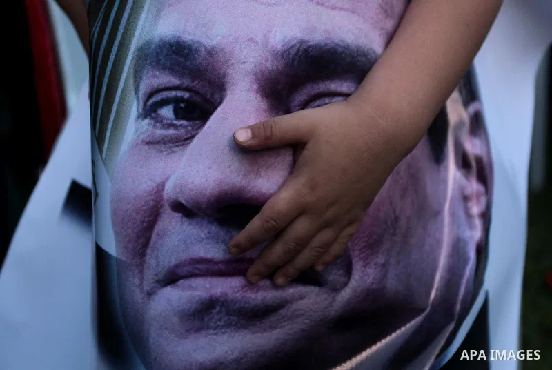Members of Egyptian community in the Gaza Strip hold Egyptian flags and pictures of ex-army chief Abdel Fattah al-Sisi as they celebrate after Sisi scored a crushing presidential election triumph, in Gaza City on June 03...