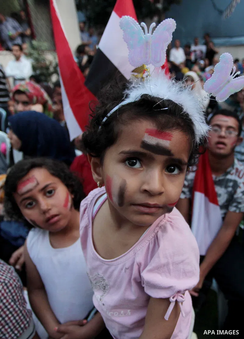 Members of Egyptian community in the Gaza Strip hold Egyptian flags and pictures of ex-army chief Abdel Fattah al-Sisi as they celebrate after Sisi scored a crushing presidential election triumph, in Gaza City on June 03...