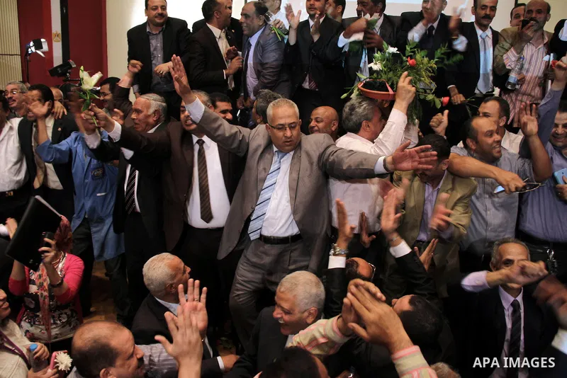Egyptian journalists and State Information Service (SIS) employees celebrate at the end of a press conference in the capital Cairo on June 3, 2014, in which the electoral commission announced that Ex-army chief Abdel Fat...
