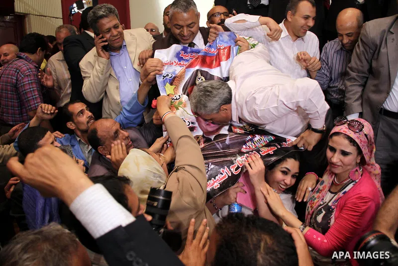 Egyptian journalists and State Information Service (SIS) employees celebrate at the end of a press conference in the capital Cairo on June 3, 2014, in which the electoral commission announced that Ex-army chief Abdel Fat...