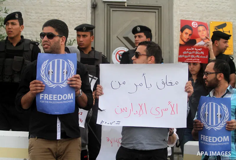 Palestinian activists hold banners during a protest outside the headquarters of the United Nations (UNRCP) in the West Bank city of Ramallah, on June 04, 2014. Protesters closed the doors of the office during a protest t...