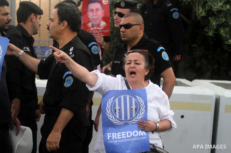 Palestinian activists hold banners during a protest outside the headquarters of the United Nations (UNRCP) in the West Bank city of Ramallah, on June 04, 2014. Protesters closed the doors of the office during a protest t...