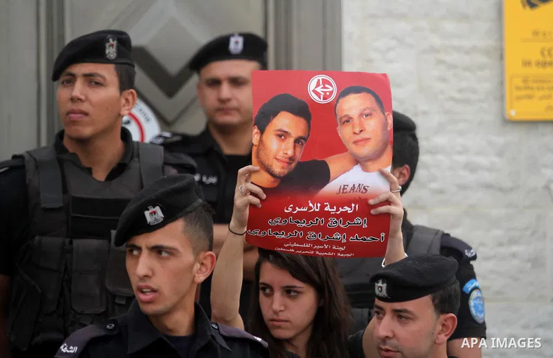 Palestinian activists hold banners during a protest outside the headquarters of the United Nations (UNRCP) in the West Bank city of Ramallah, on June 04, 2014. Protesters closed the doors of the office during a protest t...