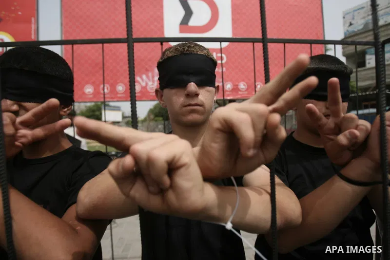 Palestinians take part a protest to solidarity with Palestinian prisoners held in Israeli jails, in Rafah in the southern Gaza strip June 04, 2014. About 120 Palestinians imprisoned without trial in Israel on an open hun...