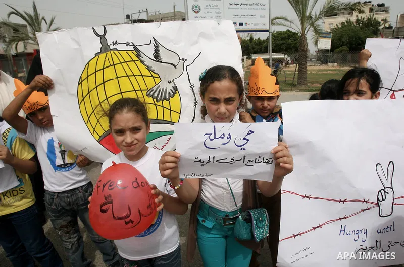 Palestinians take part a protest to solidarity with Palestinian prisoners held in Israeli jails, in Rafah in the southern Gaza strip June 04, 2014. About 120 Palestinians imprisoned without trial in Israel on an open hun...