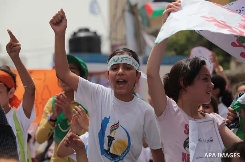 Palestinian children take part in a summer camp organized by Hamas on June 4, 2014. Thousands of elementary school students in the Gaza Strip are going to Hamas summer camps, in which they take part in recreational activ...
