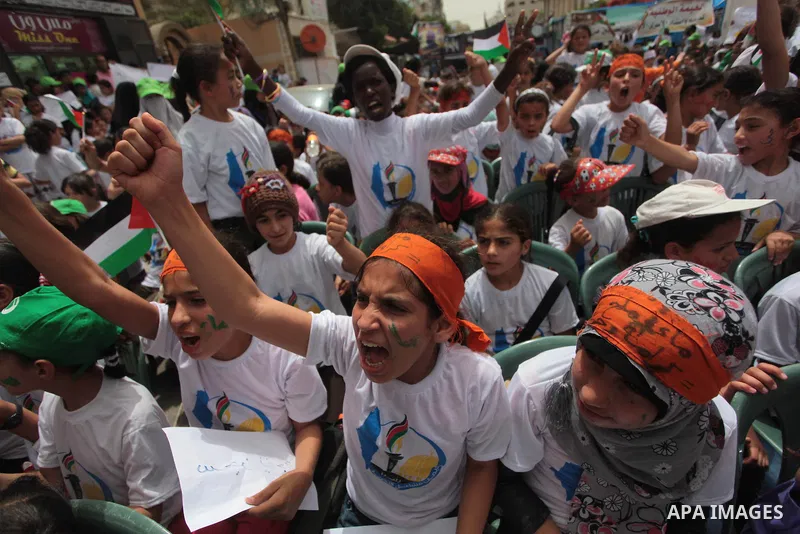 Palestinian children take part in a summer camp organized by Hamas on June 4, 2014. Thousands of elementary school students in the Gaza Strip are going to Hamas summer camps, in which they take part in recreational activ...