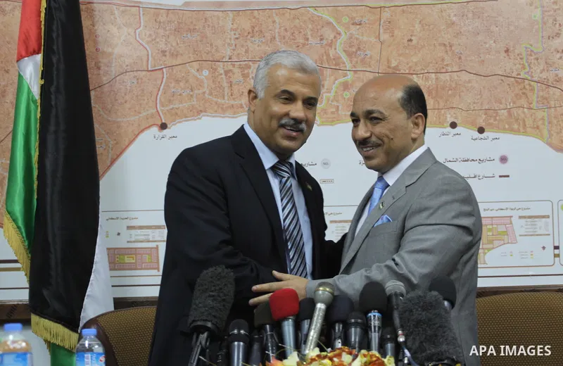 Former Palestinian housing minister Yousef al-Ghorez (L), and new minister of housing in the Palestinian unity government Mufid al-Hasayneh (R), attend a joint press conference to hand over the ministry's duties, in Gaza...