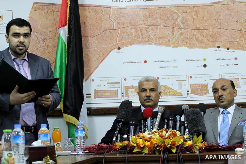 Former Palestinian housing minister Yousef al-Ghorez (L), and new minister of housing in the Palestinian unity government Mufid al-Hasayneh (R), attend a joint press conference to hand over the ministry's duties, in Gaza...