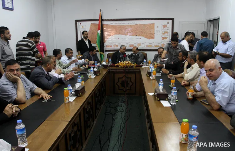 Former Palestinian housing minister Yousef al-Ghorez (L), and new minister of housing in the Palestinian unity government Mufid al-Hasayneh (R), attend a joint press conference to hand over the ministry's duties, in Gaza...