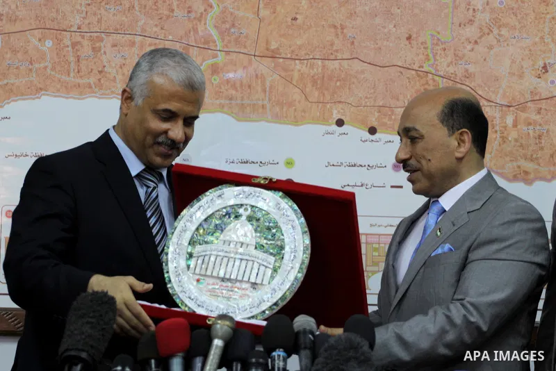 Former Palestinian housing minister Yousef al-Ghorez (L), and new minister of housing in the Palestinian unity government Mufid al-Hasayneh (R), attend a joint press conference to hand over the ministry's duties, in Gaza...