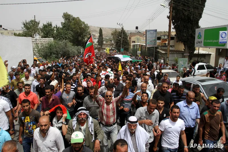 Palestinians carry the body of Alaa Odeh during his funeral in Huwara village near Nablus, the northern West Bank, Wednesday, June 4, 2014. The Israeli military says troops shot and killed Odeh at a checkpoint after he o...
