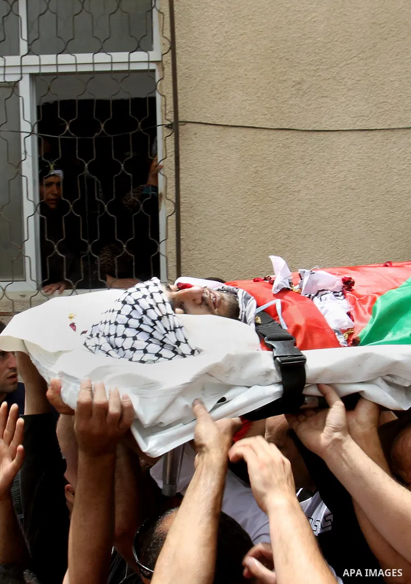 Palestinians carry the body of Alaa Odeh during his funeral in Huwara village near Nablus, the northern West Bank, Wednesday, June 4, 2014. The Israeli military says troops shot and killed Odeh at a checkpoint after he o...
