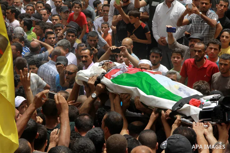 Palestinians carry the body of Alaa Odeh during his funeral in Huwara village near Nablus, the northern West Bank, Wednesday, June 4, 2014. The Israeli military says troops shot and killed Odeh at a checkpoint after he o...