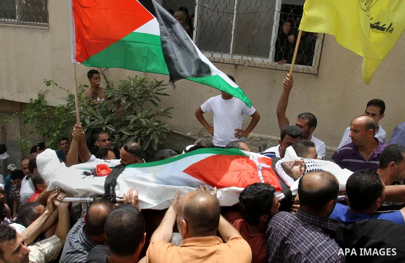 Palestinians carry the body of Alaa Odeh during his funeral in Huwara village near Nablus, the northern West Bank, Wednesday, June 4, 2014. The Israeli military says troops shot and killed Odeh at a checkpoint after he o...