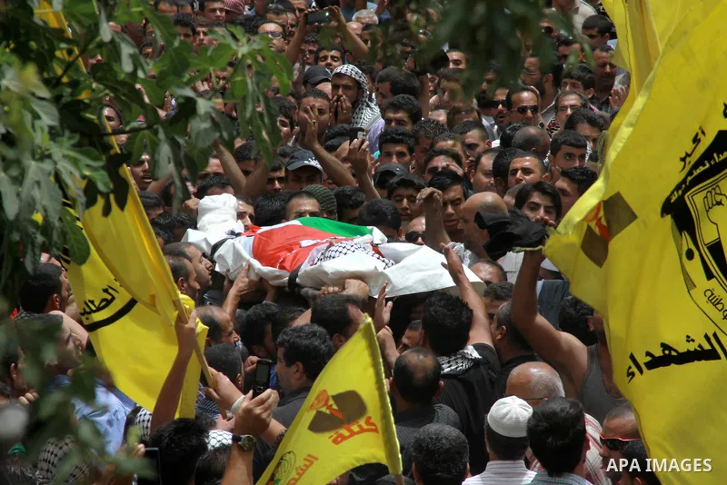 Palestinians carry the body of Alaa Odeh during his funeral in Huwara village near Nablus, the northern West Bank, Wednesday, June 4, 2014. The Israeli military says troops shot and killed Odeh at a checkpoint after he o...