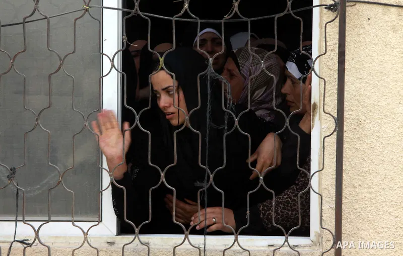 Palestinian wife Eman Odeh mourns the body of Alaa Odeh during his funeral in Huwara village near Nablus, the northern West Bank, Wednesday, June 4, 2014. The Israeli military says troops shot and killed Odeh at a checkp...