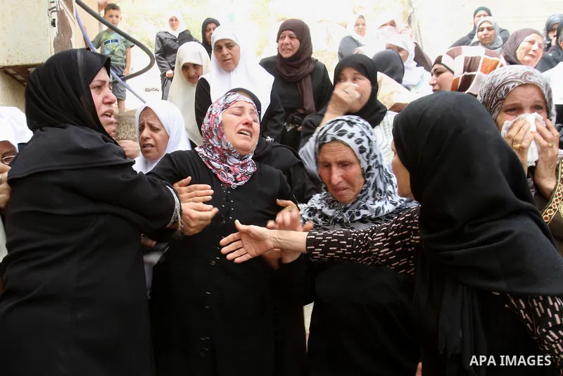 Palestinian relatives of Alaa Odeh mourn during his funeral in Huwara village near Nablus, the northern West Bank, Wednesday, June 4, 2014. The Israeli military says troops shot and killed Odeh at a checkpoint after he o...