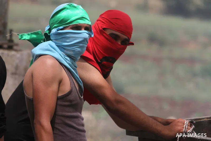 Masked Palestinian protesters take part in a protest in support of Palestinian prisoners hunger striking since 42 days in Israeli jails, outside Ofer, an Israeli military prison near the West Bank city of Ramallah, Wedne...
