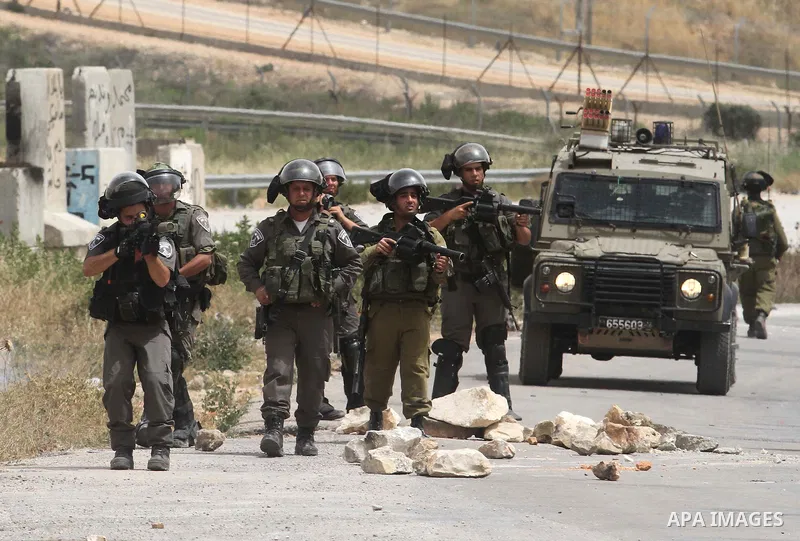 An Israeli border police officer fires a tear gas canister during clashes with Palestinians after a protest in support of Palestinian prisoners hunger striking since 42 days in Israeli jails, outside Ofer, an Israeli mil...