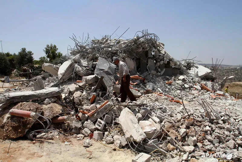 A Palestinian man inspects his house destroyed by the Israeli army bulldozers in Pharaoh village near the West Bank city of Tulkarem, on June 9, 2014. The Israeli army bulldozers demolished the house of a Palestinian fam...