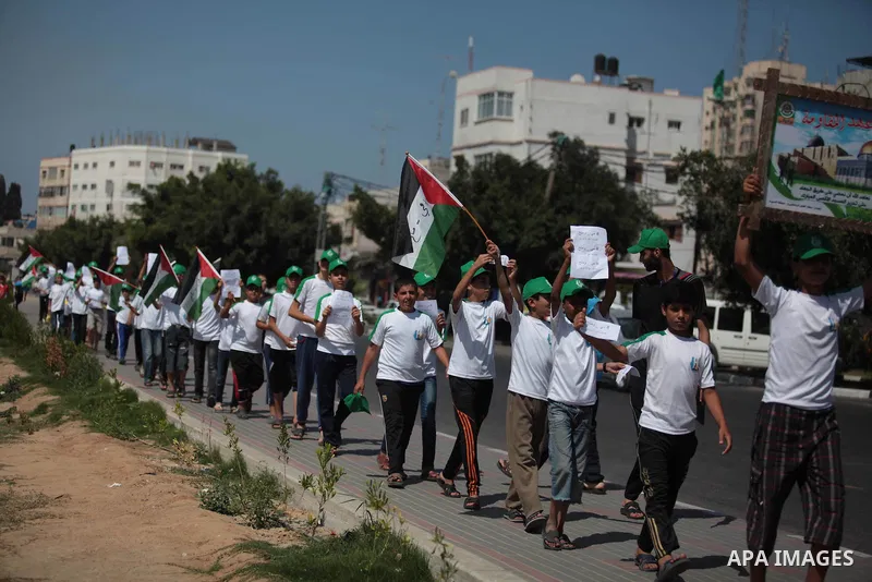 Palestinian boys form a human chain during a protest to support prisoners in Israeli jails, in Gaza city, on June 10, 2014. Palestinians jailed without trial in Israel are on a hunger strike since 24 April 2014, demandin...