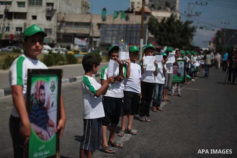 Palestinian boys form a human chain during a protest to support prisoners in Israeli jails, in Gaza city, on June 10, 2014. Palestinians jailed without trial in Israel are on a hunger strike since 24 April 2014, demandin...