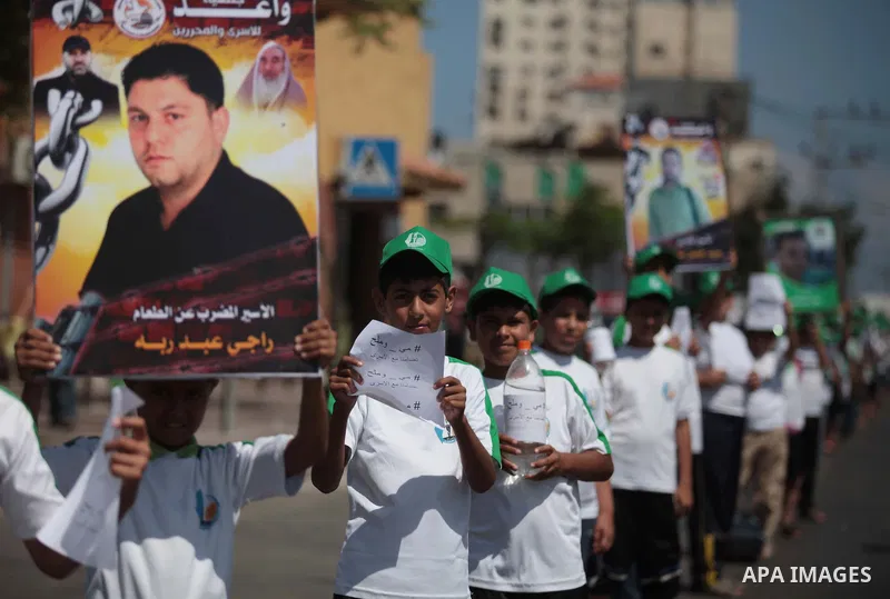 Palestinian boys form a human chain during a protest to support prisoners in Israeli jails, in Gaza city, on June 10, 2014. Palestinians jailed without trial in Israel are on a hunger strike since 24 April 2014, demandin...