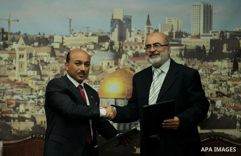 Former deputy premier of the government in Gaza Strip Ziad Thatha (R), meets with Palestinian Minister of public works and housing of the new unity government, Mufid al-Hasayna during the handover ceremony of the headqua...