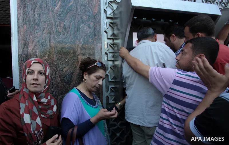 Employees paid by the Palestinian Authority wait to receive their salaries outside a bank after a scuffle with employees appointed by Hamas since 2007, in Gaza City on June 11, 2014. Gaza's banks reopened Wednesday after...