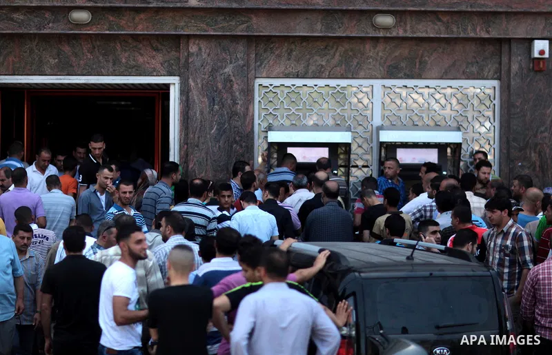 Employees paid by the Palestinian Authority wait to receive their salaries outside a bank after a scuffle with employees appointed by Hamas since 2007, in Gaza City on June 11, 2014. Gaza's banks reopened Wednesday after...
