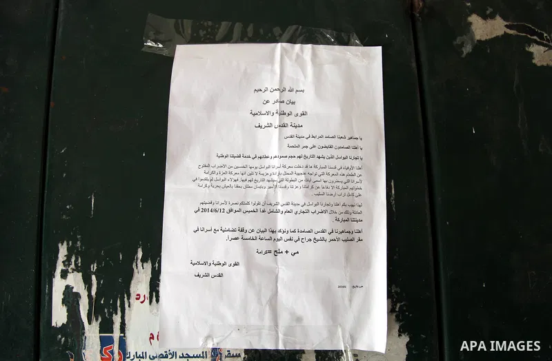 The statement of Palestinian National and Islamic Forces is seen in front of a closed shop in Jerusalem's Old City June 12, 2014. Shops were shuttered in East Jerusalem on Thursday to show solidarity with hundreds of Pal...