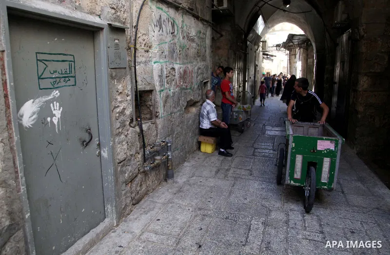 People walk past closed shops in Jerusalem's Old City June 12, 2014. Shops were shuttered in East Jerusalem on Thursday to show solidarity with hundreds of Palestinian prisoners in Israeli jails who have joined a hunger...