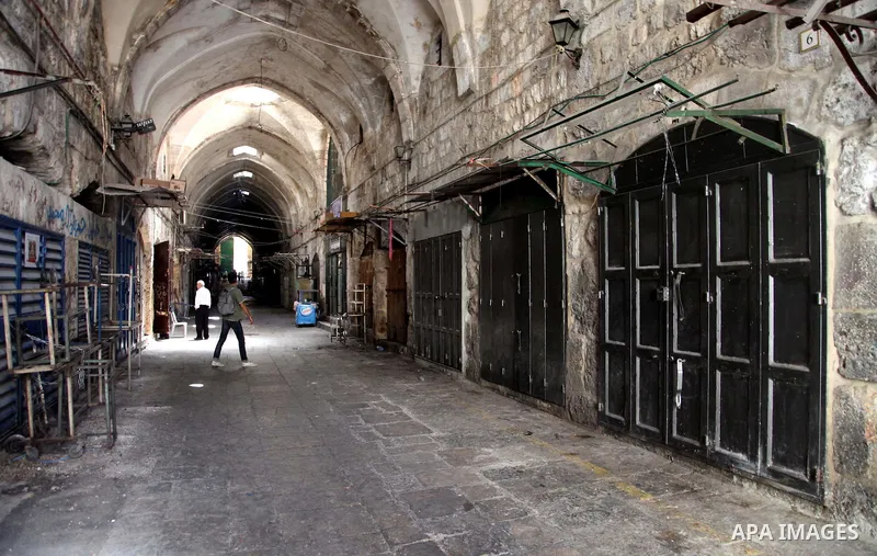 People walk past closed shops in Jerusalem's Old City June 12, 2014. Shops were shuttered in East Jerusalem on Thursday to show solidarity with hundreds of Palestinian prisoners in Israeli jails who have joined a hunger...