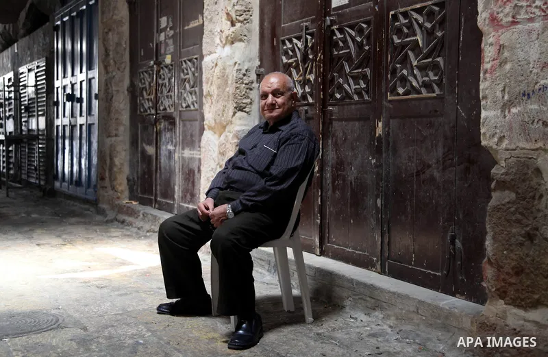 A Palestinian man sits in front of closed shops in Jerusalem's Old City June 12, 2014. Shops were shuttered in East Jerusalem on Thursday to show solidarity with hundreds of Palestinian prisoners in Israeli jails who hav...