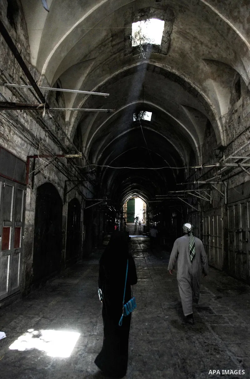 People walk past closed shops in Jerusalem's Old City June 12, 2014. Shops were shuttered in East Jerusalem on Thursday to show solidarity with hundreds of Palestinian prisoners in Israeli jails who have joined a hunger...